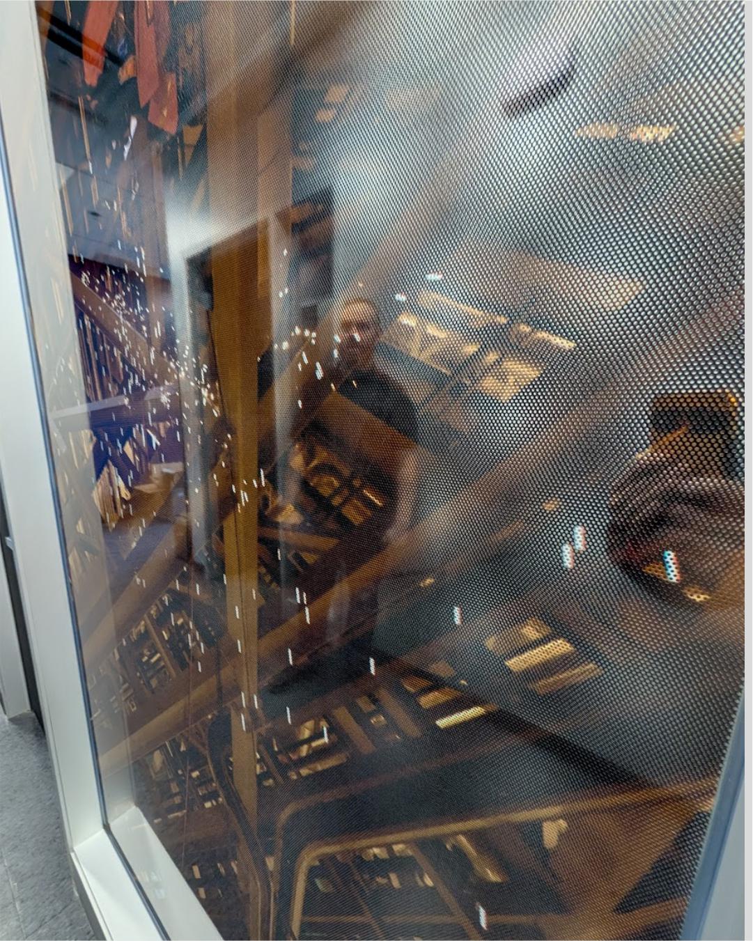 Perforated-Window-Film-Detail-Texture. Close-up detail of perforated window film (perf vinyl) showing the one-way vision dot pattern for office privacy.