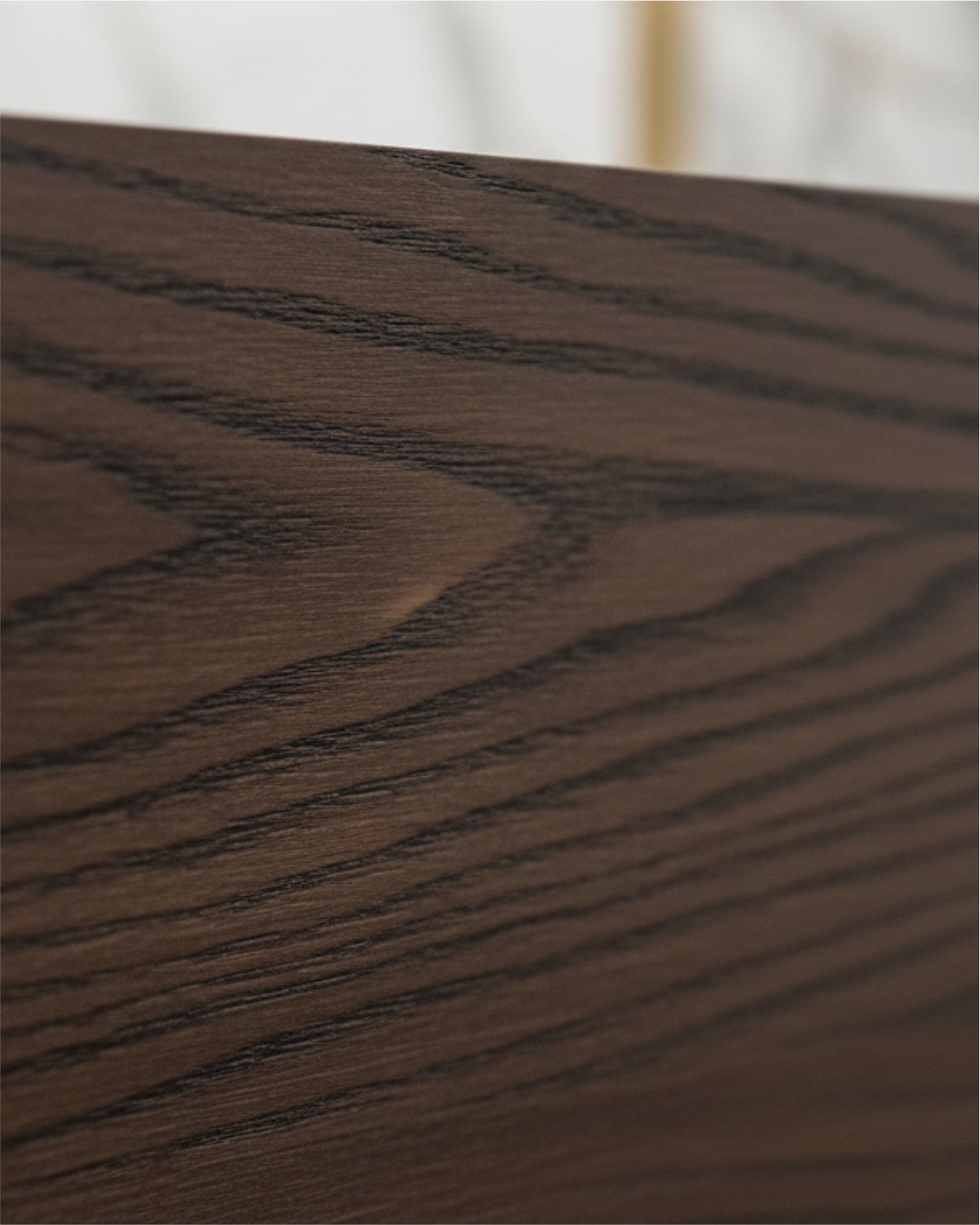 Macro close-up of a dark wood grain architectural film showing the realistic brushed texture and matte finish.